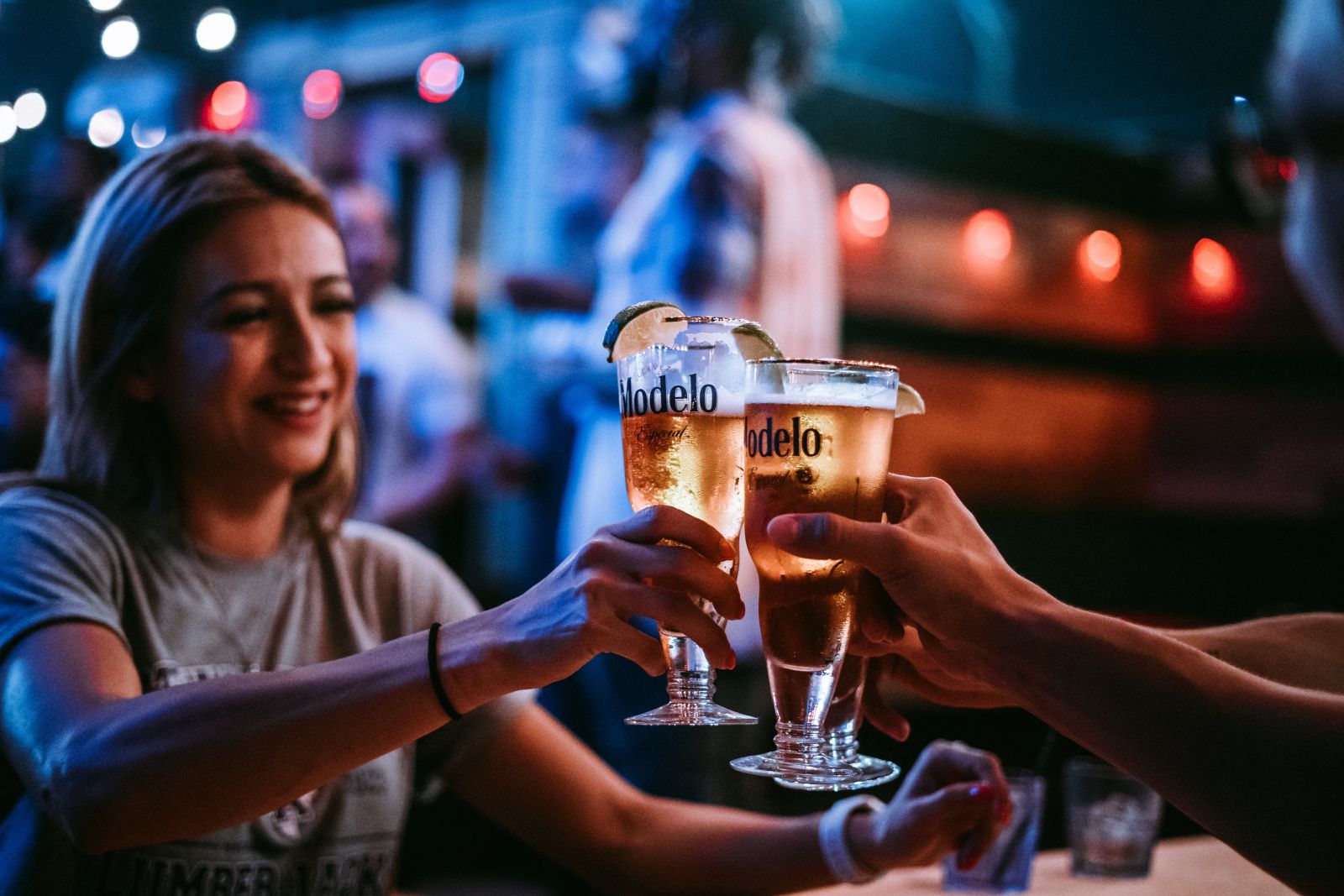 Mulher brindando cerveja com outra pessoa