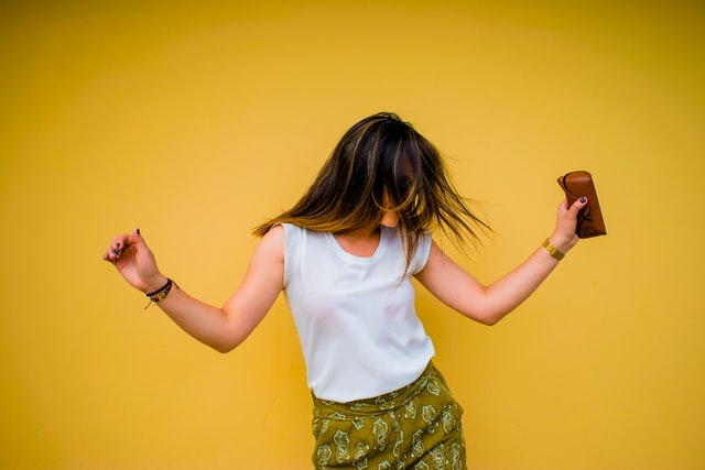 Mulher dançando com fundo amarelo