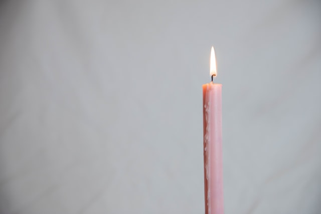 Vela rosa acesa.