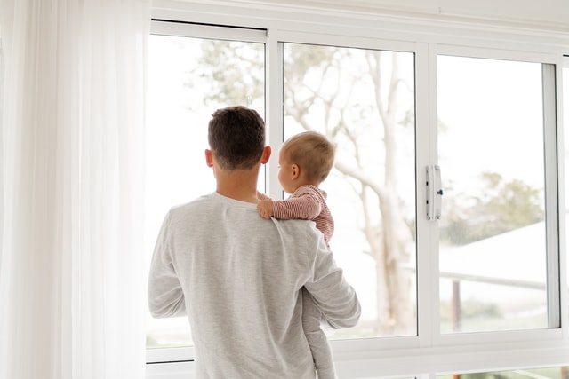 Homem branco com bebê no colo.