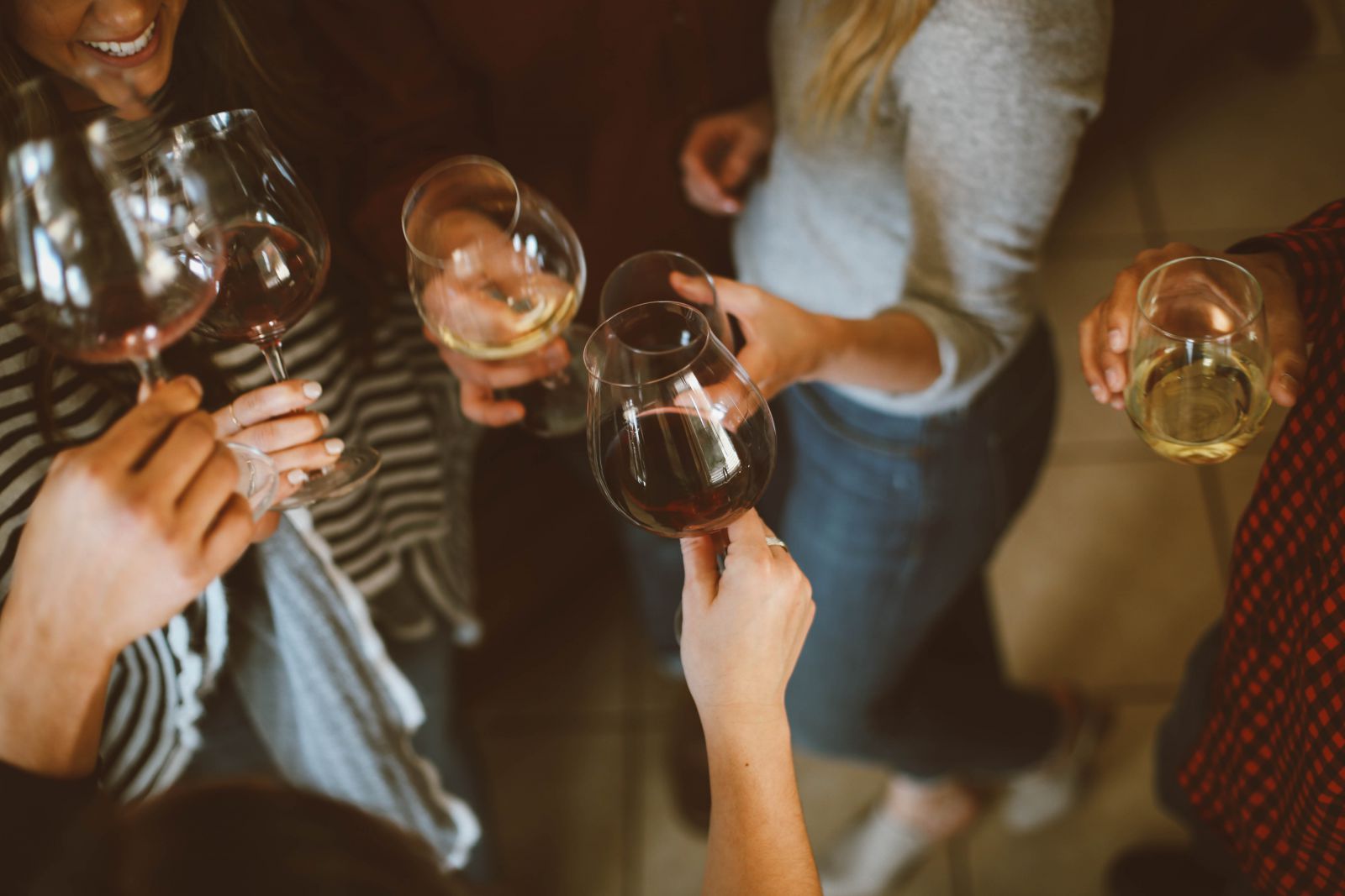 Pessoas brindando com taças de vinho em uma festa.