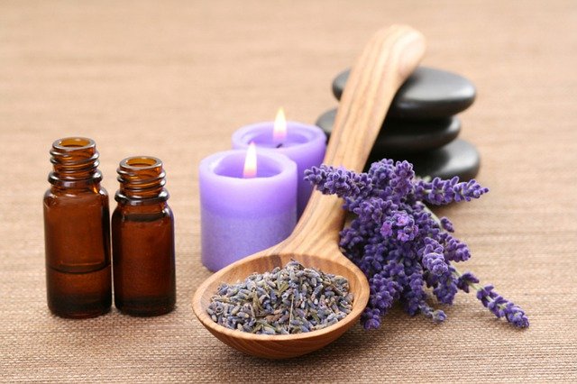 Ramos de lavanda com velas roxas e pote de vidro ao lado.