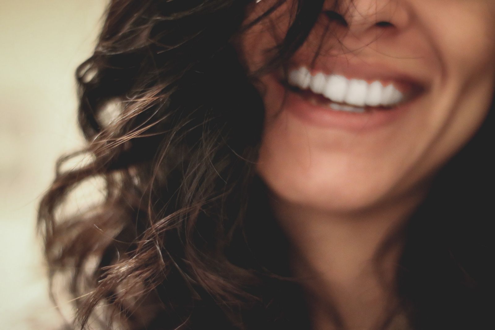 Sorriso de uma mulher com cabelo em seu rosto