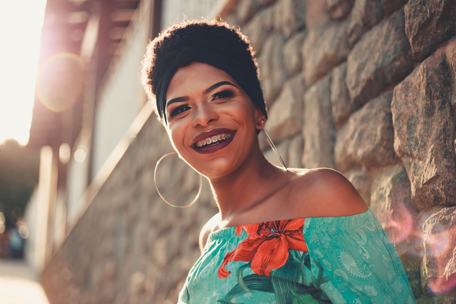 Mulher sorrindo ao lado de um muro 