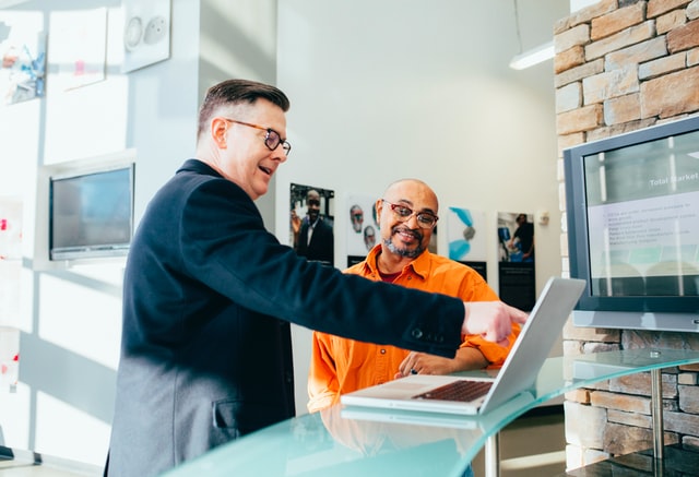 Homens trabalhando em frente a um computador.
