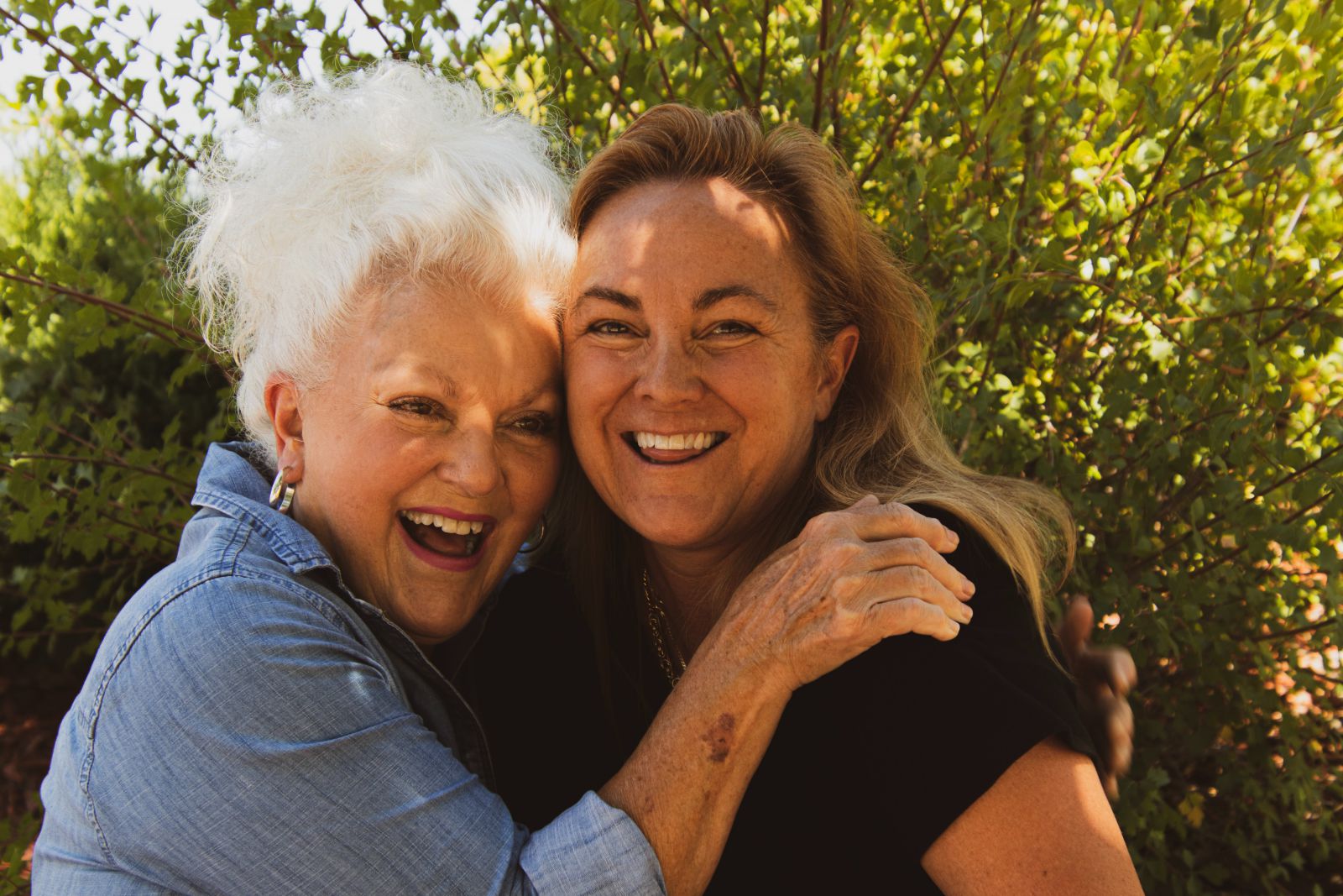 Duas mulheres sorrindo e se abraçando 