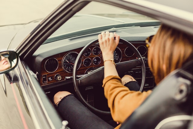 Mulher dirigindo um carro antigo