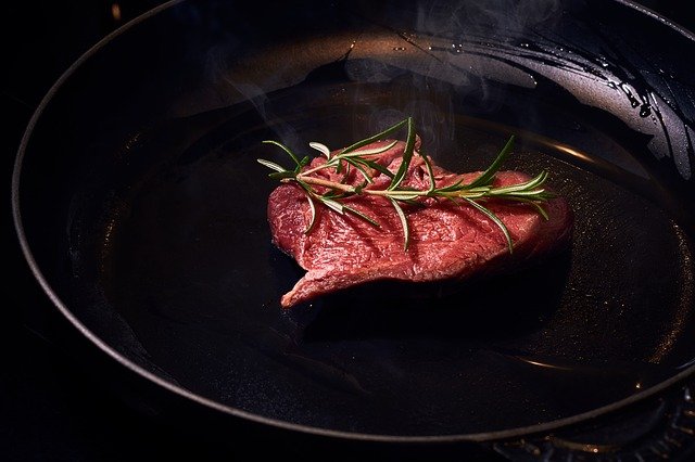 Carne crua numa frigideira.