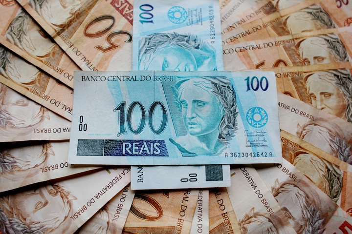 Notas de cem no meio de notas de cinquenta reais.