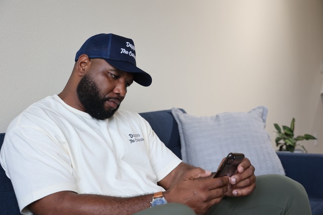 Homem branco usando celular.