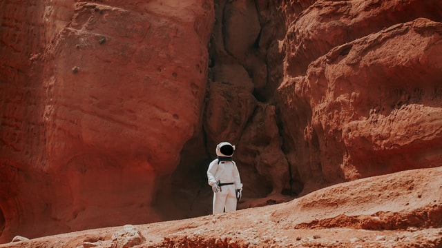 Astronauta em terra vermelha.
