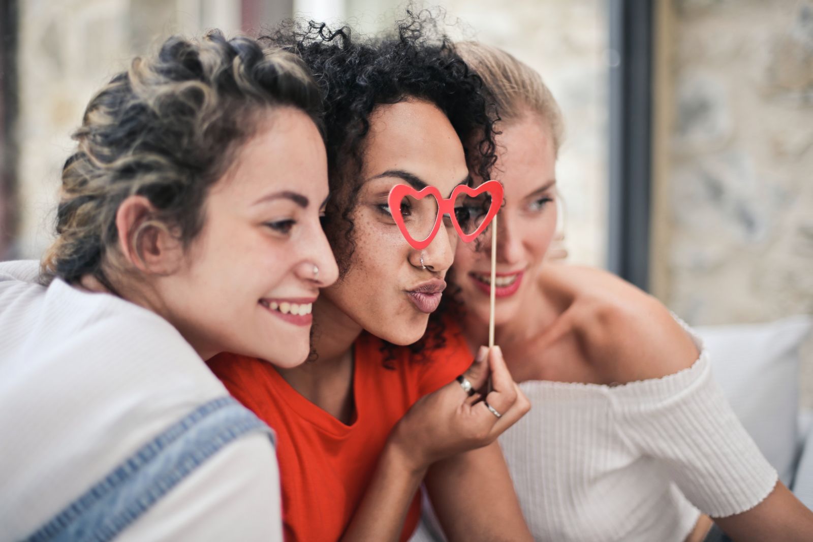 Mulher ao lado de outra duas mulheres sorrindo