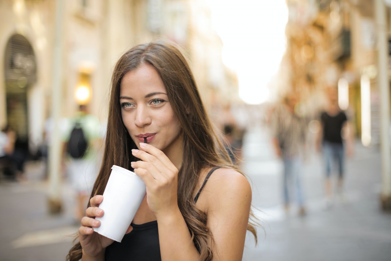 Mulher tomando algo em um copo de plástico
