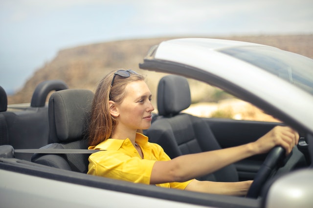 Mulher dirigindo um carro conversível