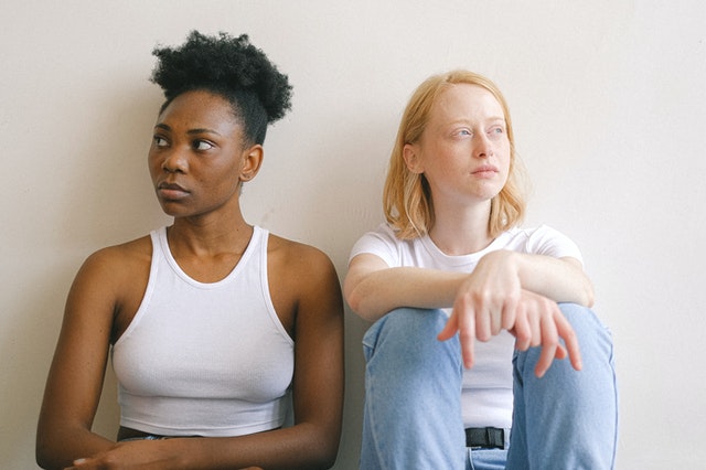 Mulher negra e mulher branca lado a lado.