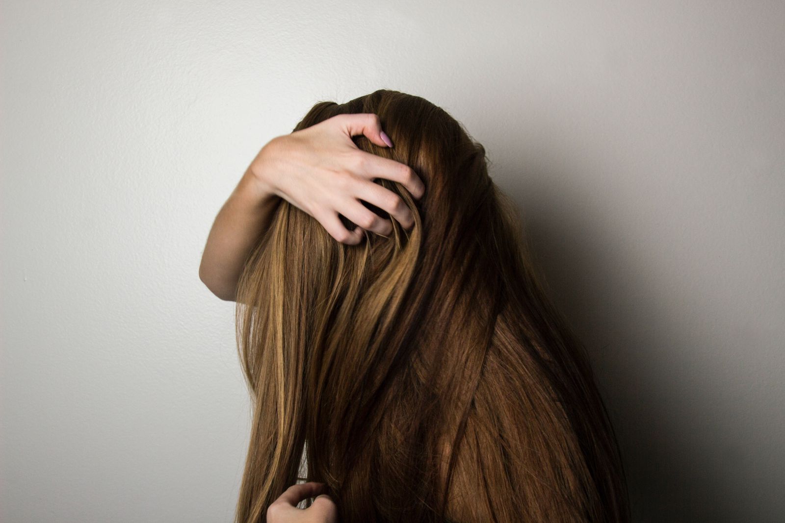 Mulher passando as mãos em seu cabelo