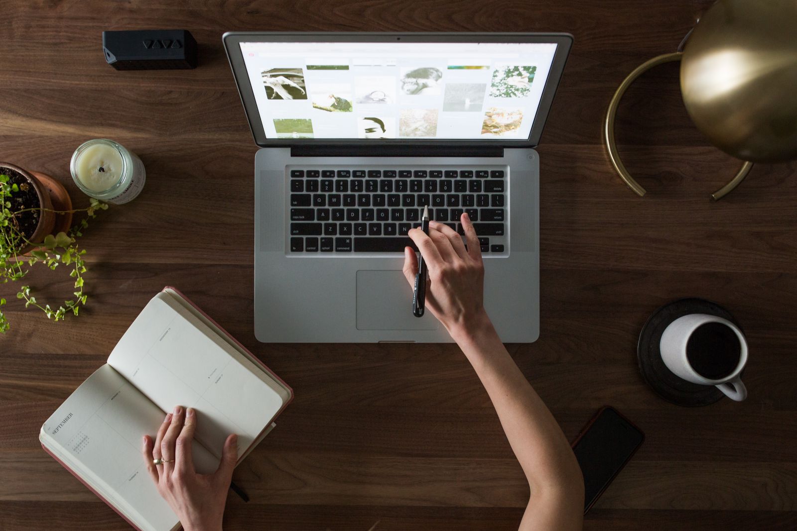 Mulher usando laptop e um caderno de anotações