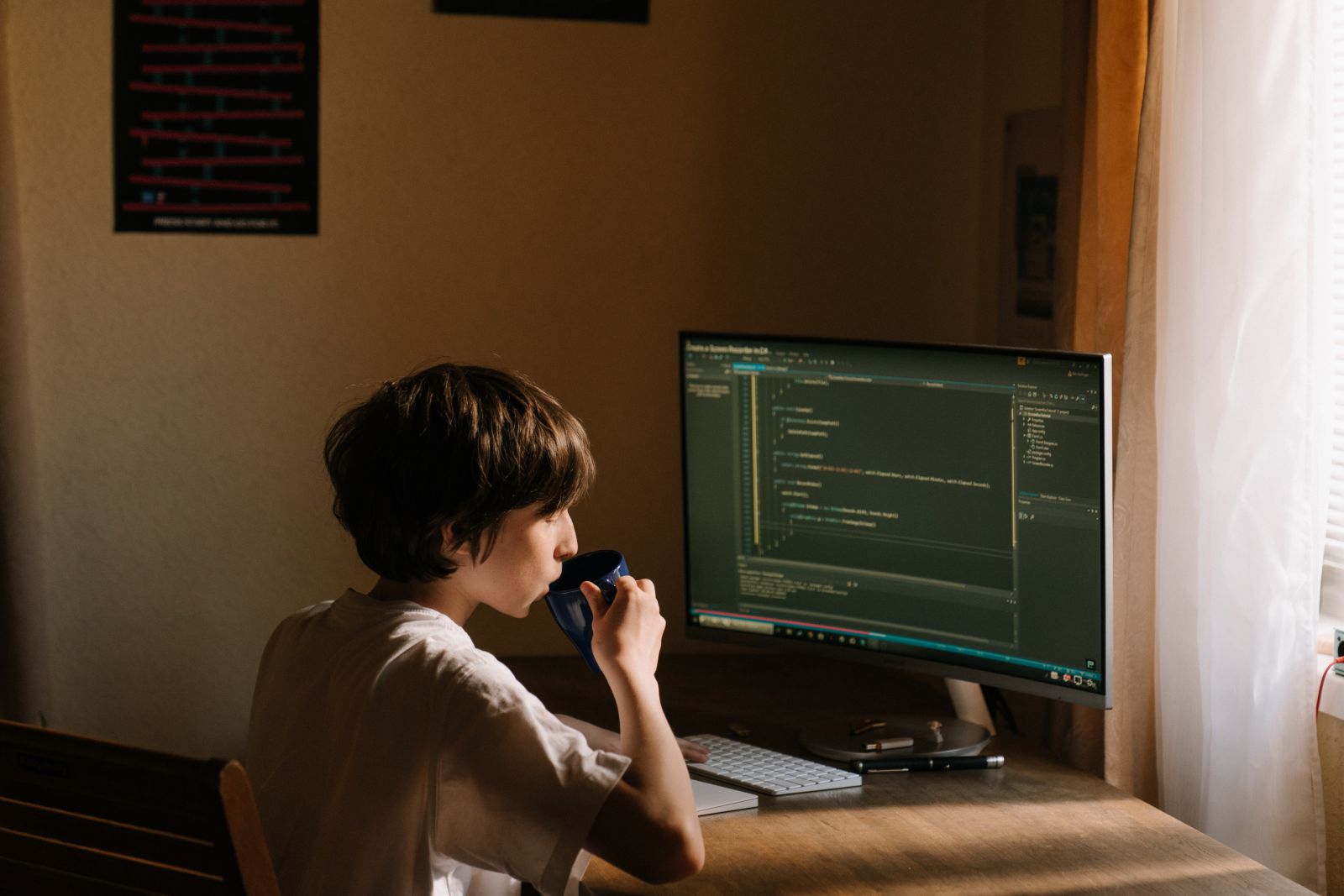 Mulher em frente a um computador trabalhando e tomando café