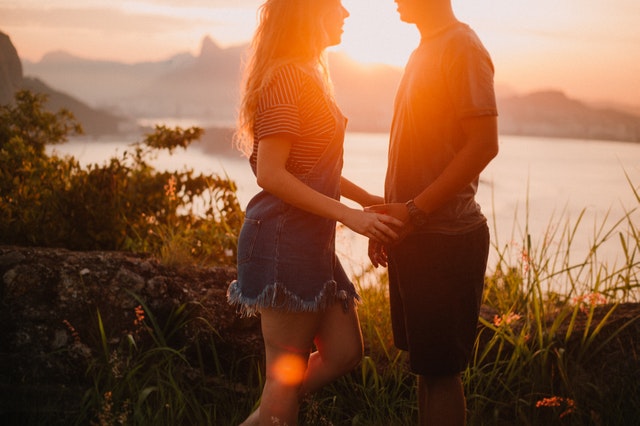 Homem e mulher de mãos dadas em frente ao mar
