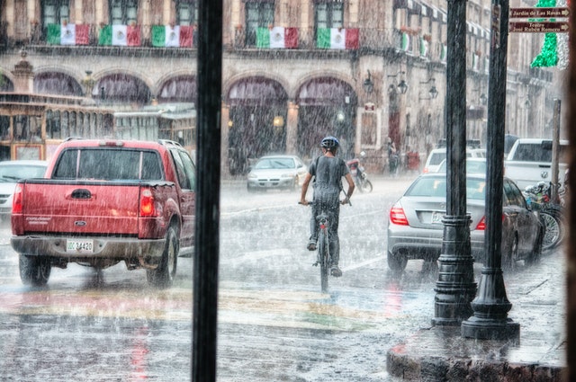 Enchente em avenida enquanto chove.