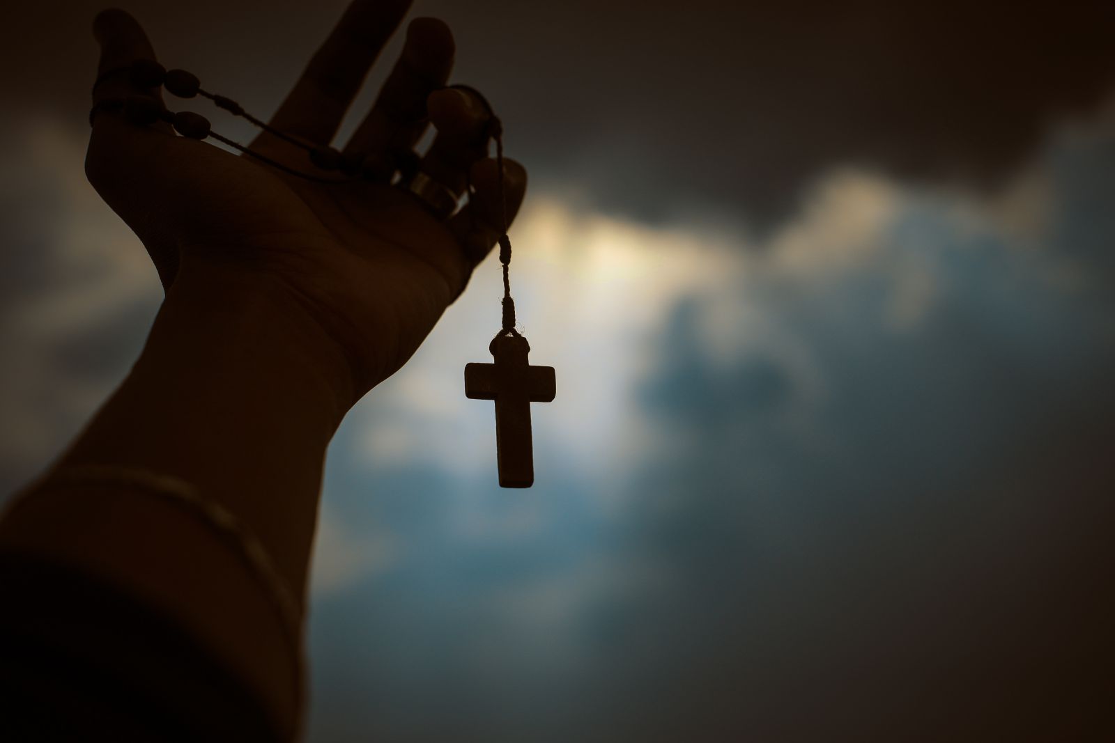 Homem segurando crucifixo 