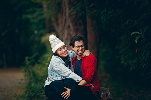 Mulher e homem brancos abraçados.