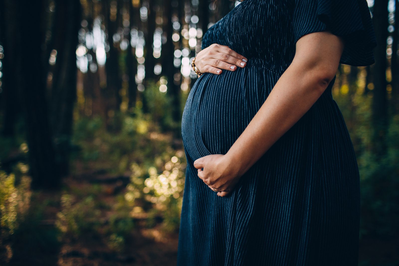 Mulher grávida com as mãos na barriga