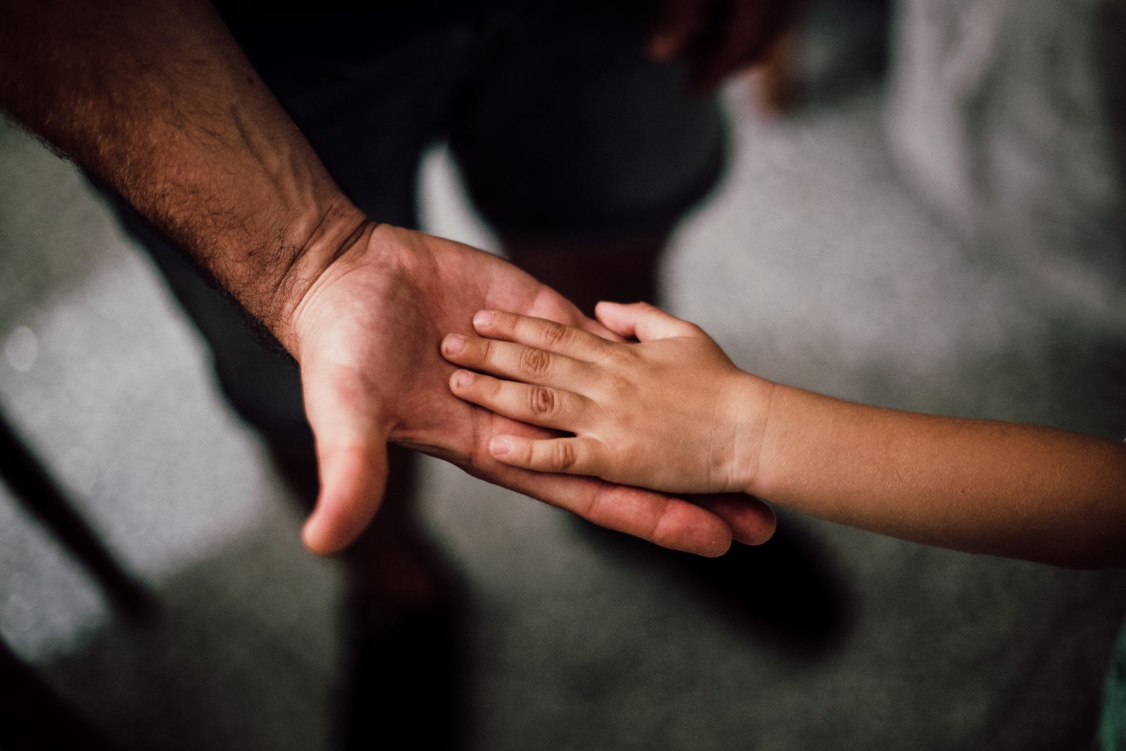 Criança e adulto com as mãos juntas