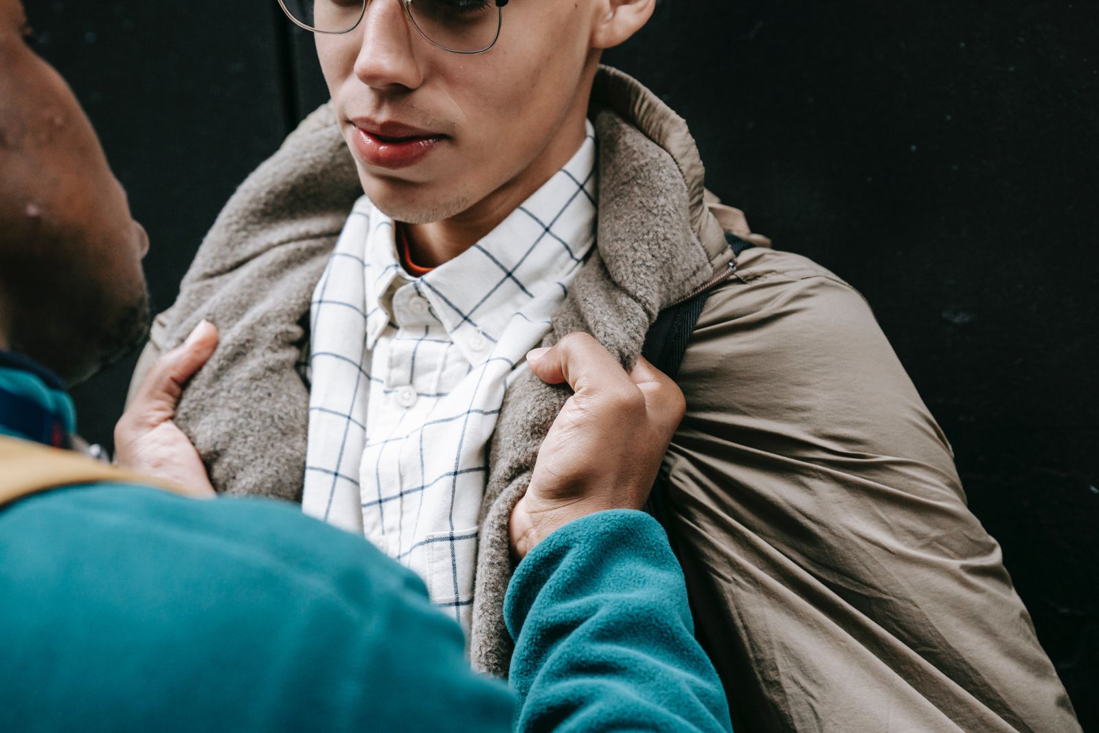 Homem segurando outro homem pela roupa agressivamente 