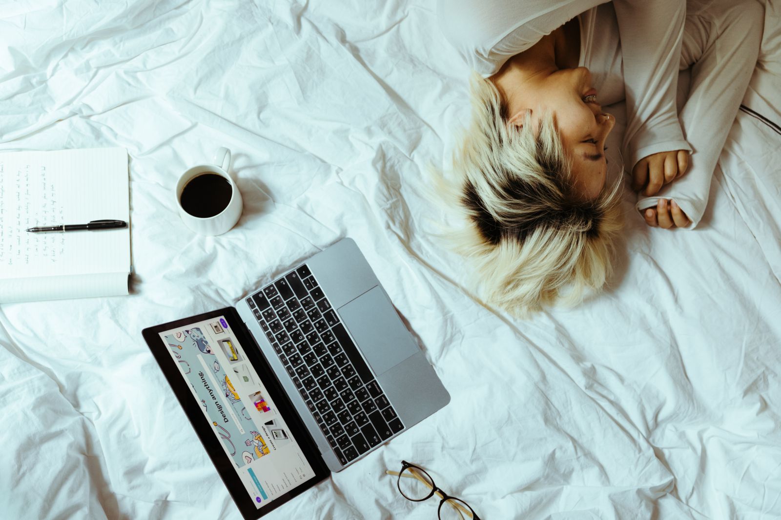 Mulher dormindo na cama com notebook aberto