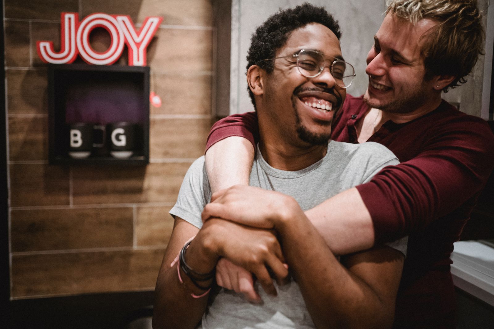 Dois homens se abraçando e sorrindo