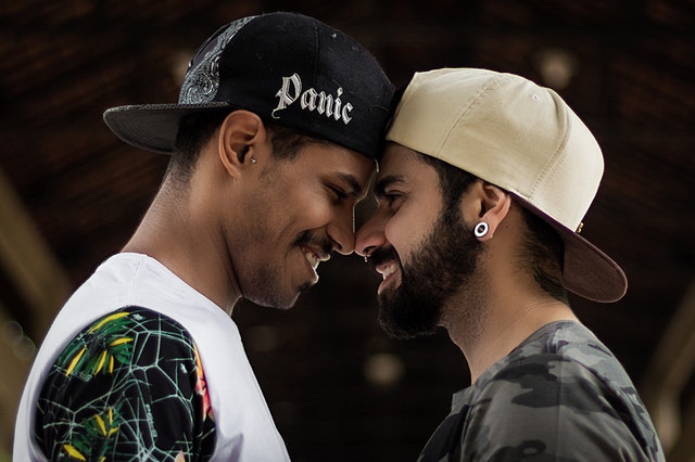 Dois homens com as testas encostadas se olhando.