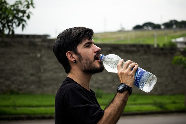 Homem de perfil tomando água
