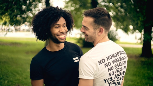 Casal de dois homens conversando em um parque