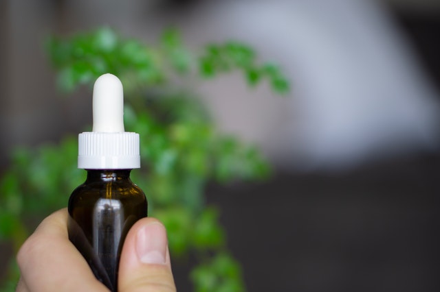 Mão segurando vidro de homeopatia