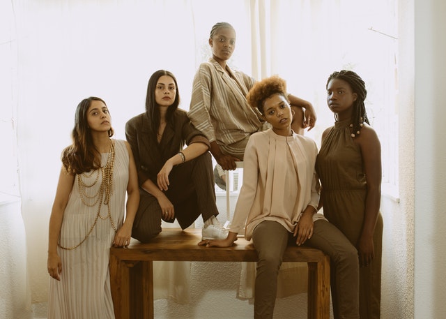 Mulheres brancas e negras com roupas neutras.