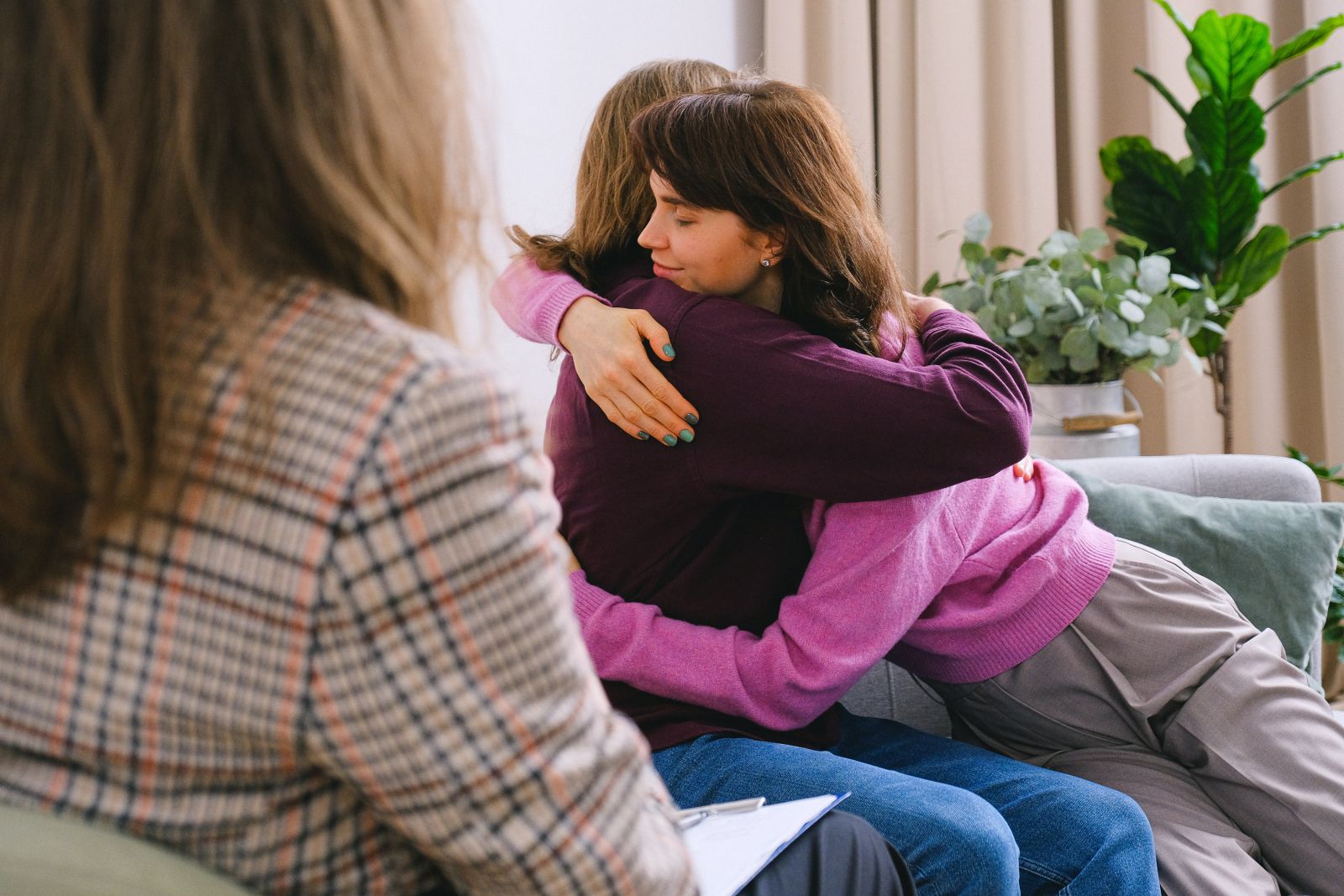 Duas mulheres se abraçando no sofá