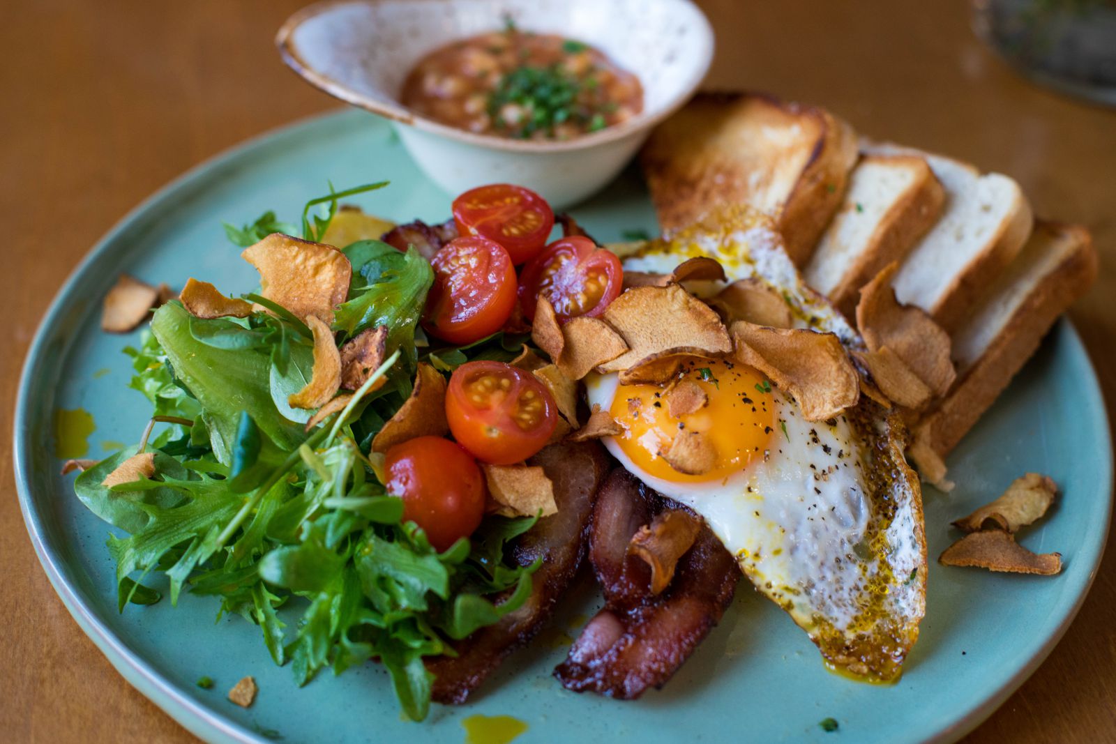 Prato com ovo, bacon, salada e pão