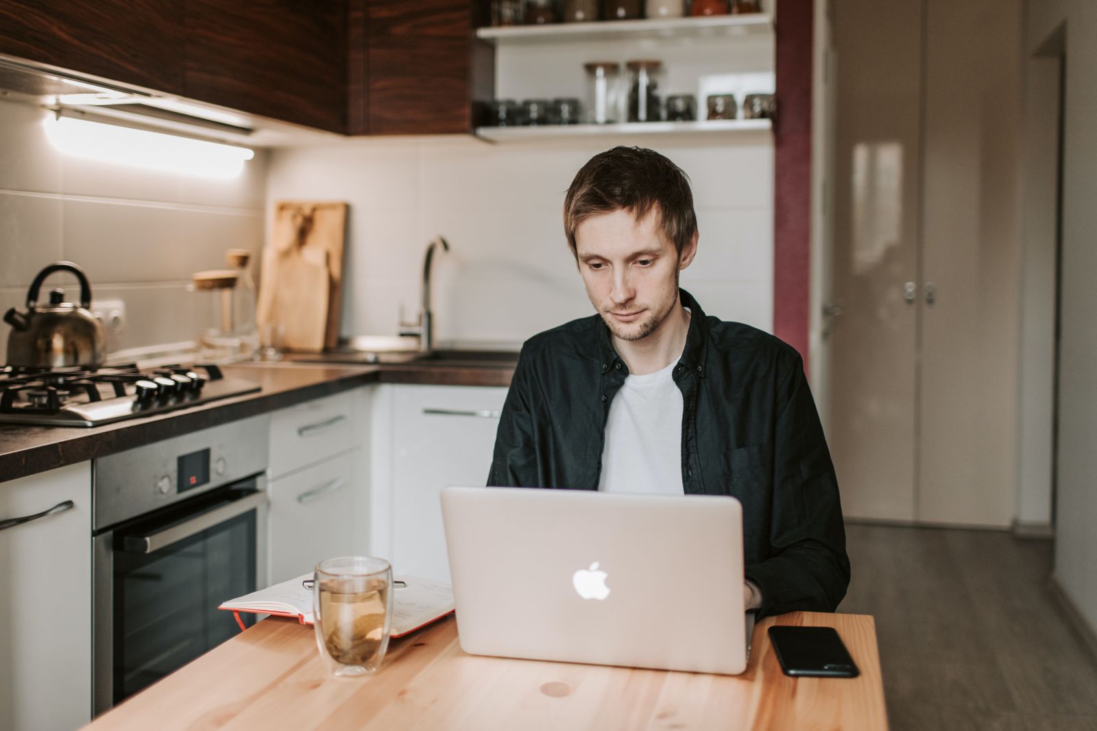 Homem em sua mesa da cozinha trabalhando no computador