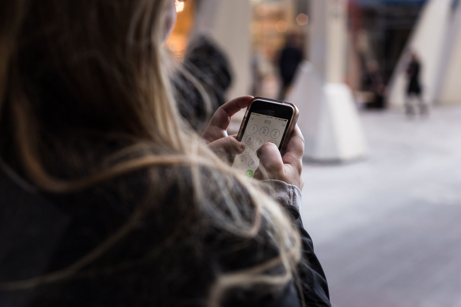 Mulher digitando no celular para ligar para alguém