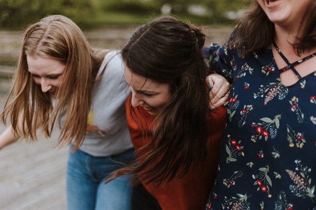 Mulheres brancas abraçadas.