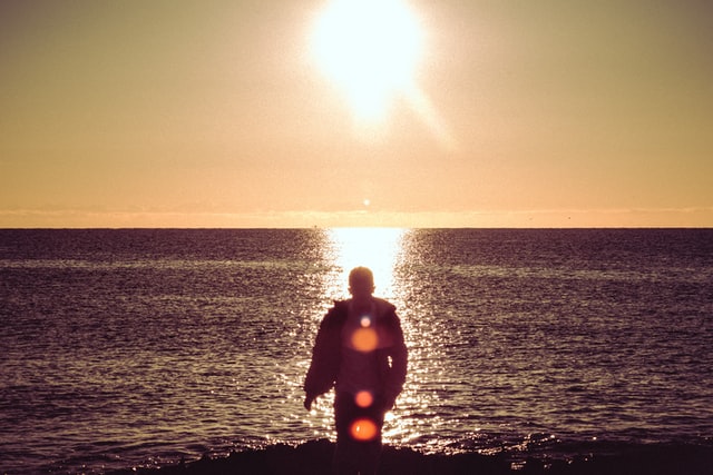 Homem de costas na praia.