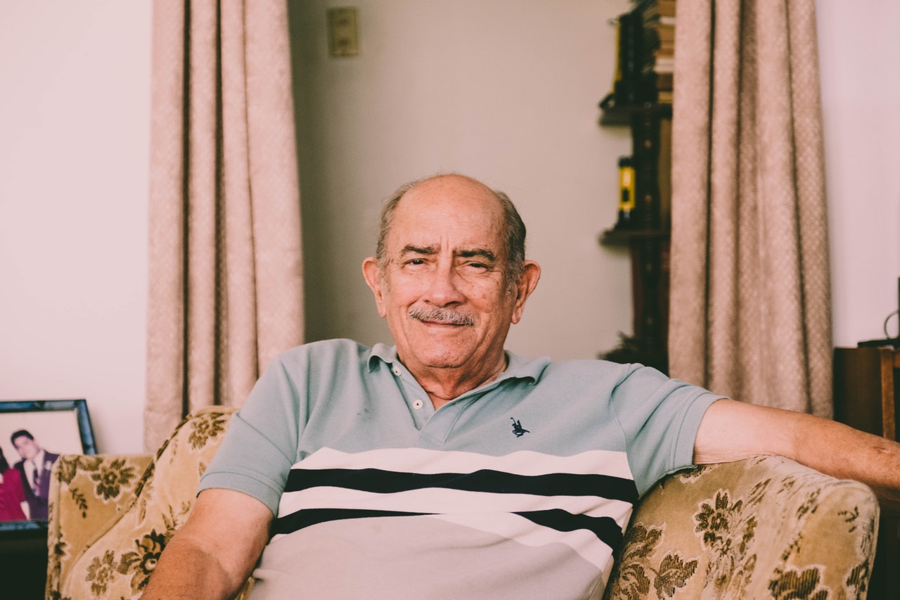 Homem sentado em uma cadeira sorrindo