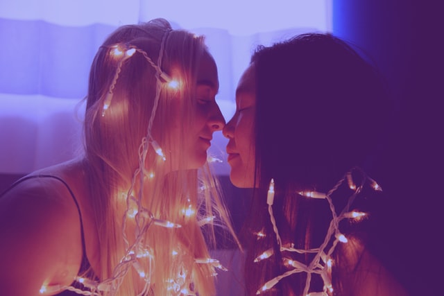 Mulheres brancas se beijando.