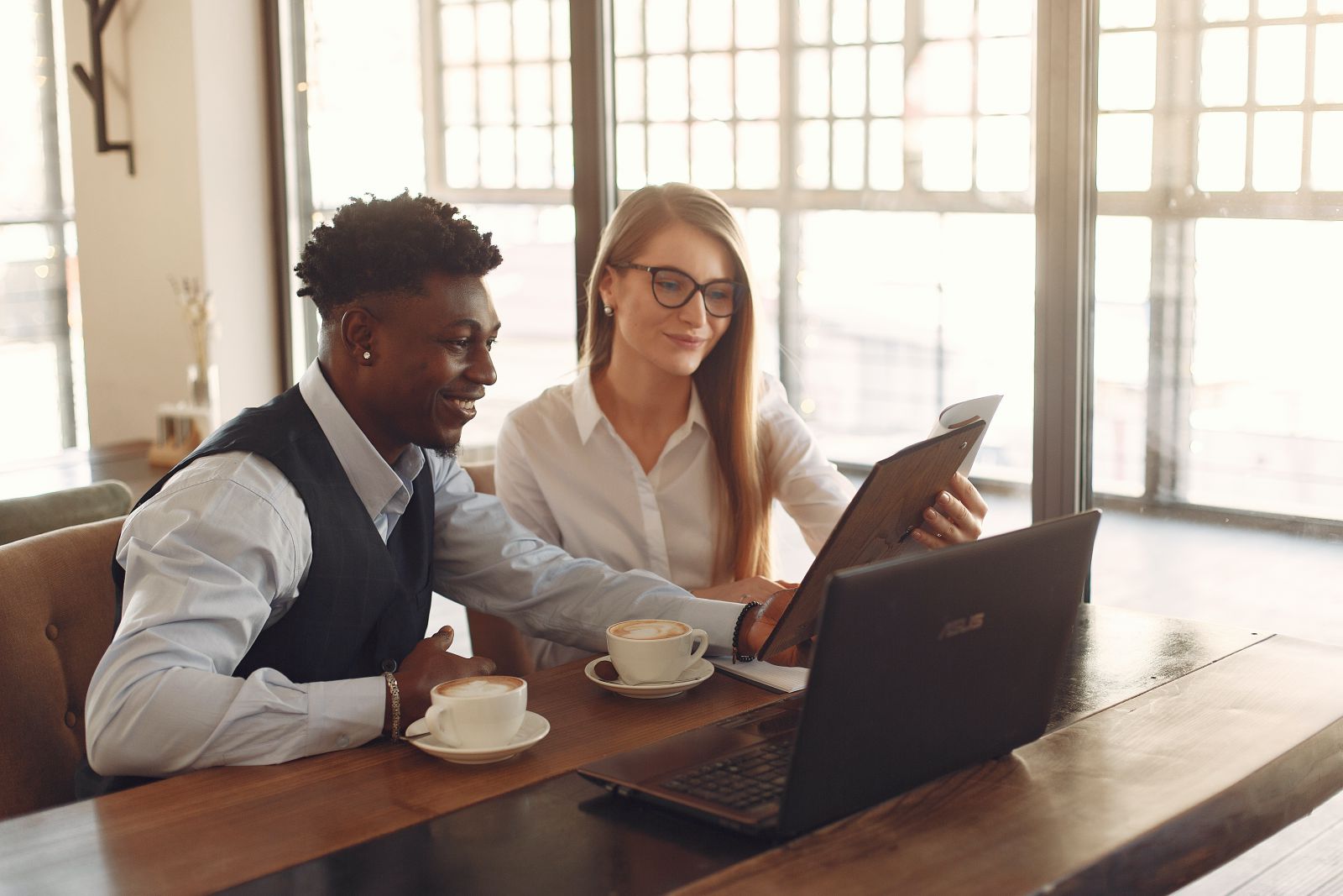 Dois colegas de trabalho conversando em uma mesa.