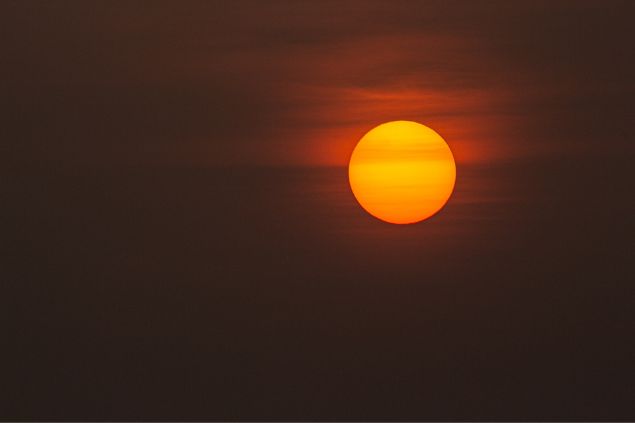 Sol brilhando em um céu escurecido.