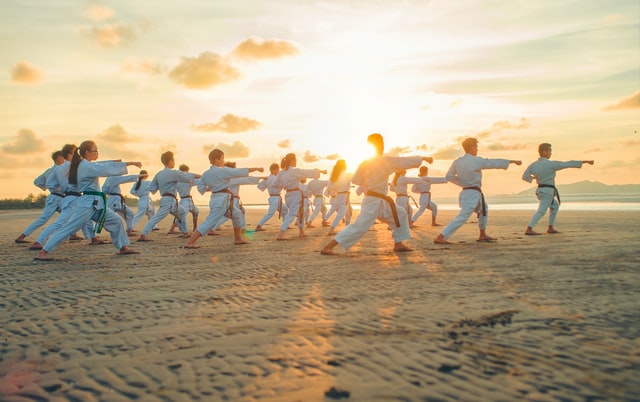 Pessoas praticando Tai-Chi numa praia.