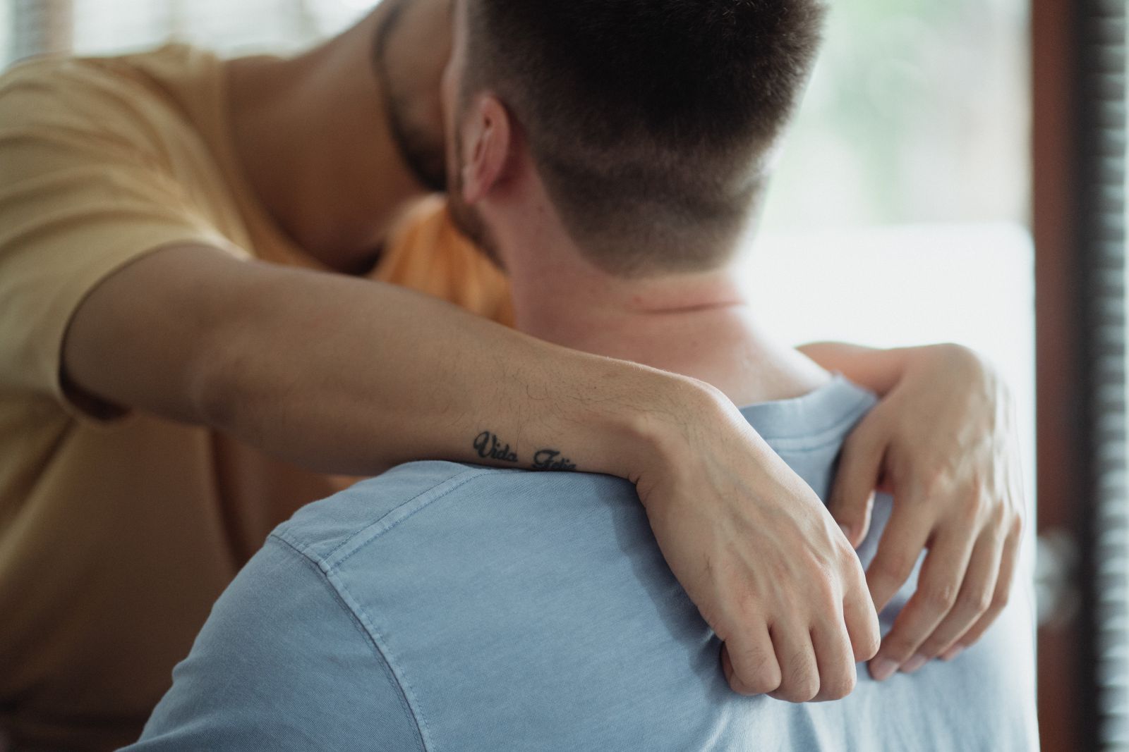 Dois homens se beijando.