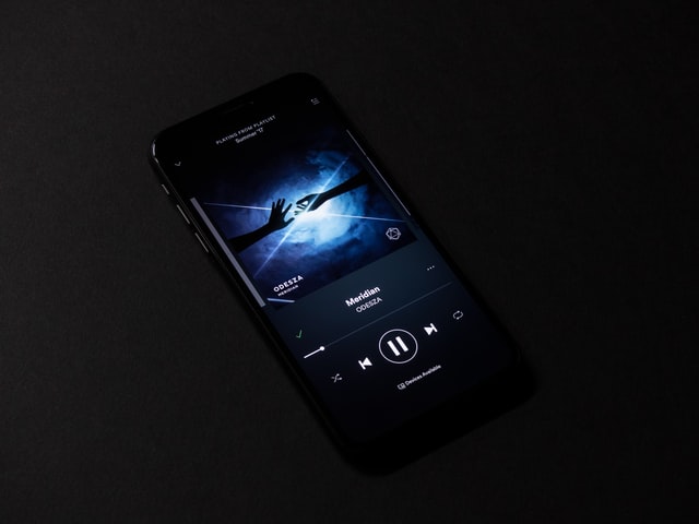 Celular preto com música tocando.