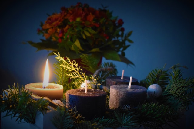 Velas acesas com plantas e flores.